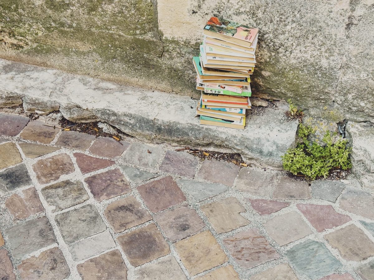 A pile of old books discarded on the pavement. Image Anthony Nelzin-Santos.