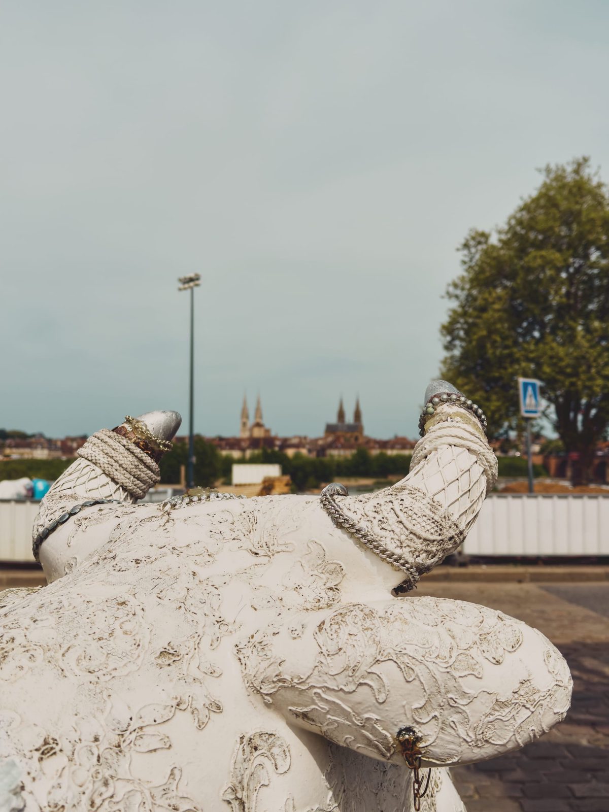 A distant view of Moulins’s churches from between the horns of a statue of a cow. Image Anthony Nelzin-Santos.