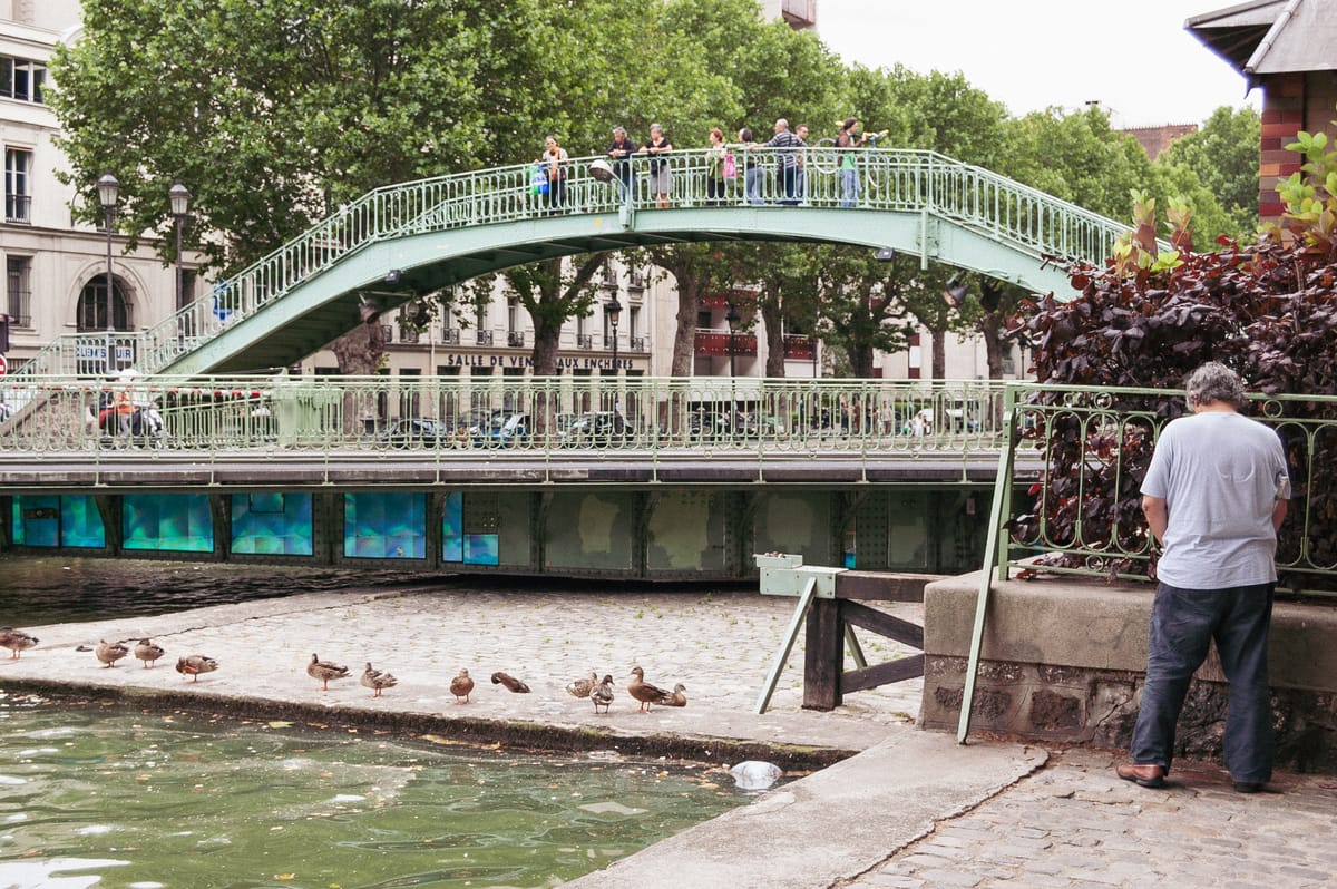 Un homme pissant près d’une passerelle du canal Saint-Martin à Paris.