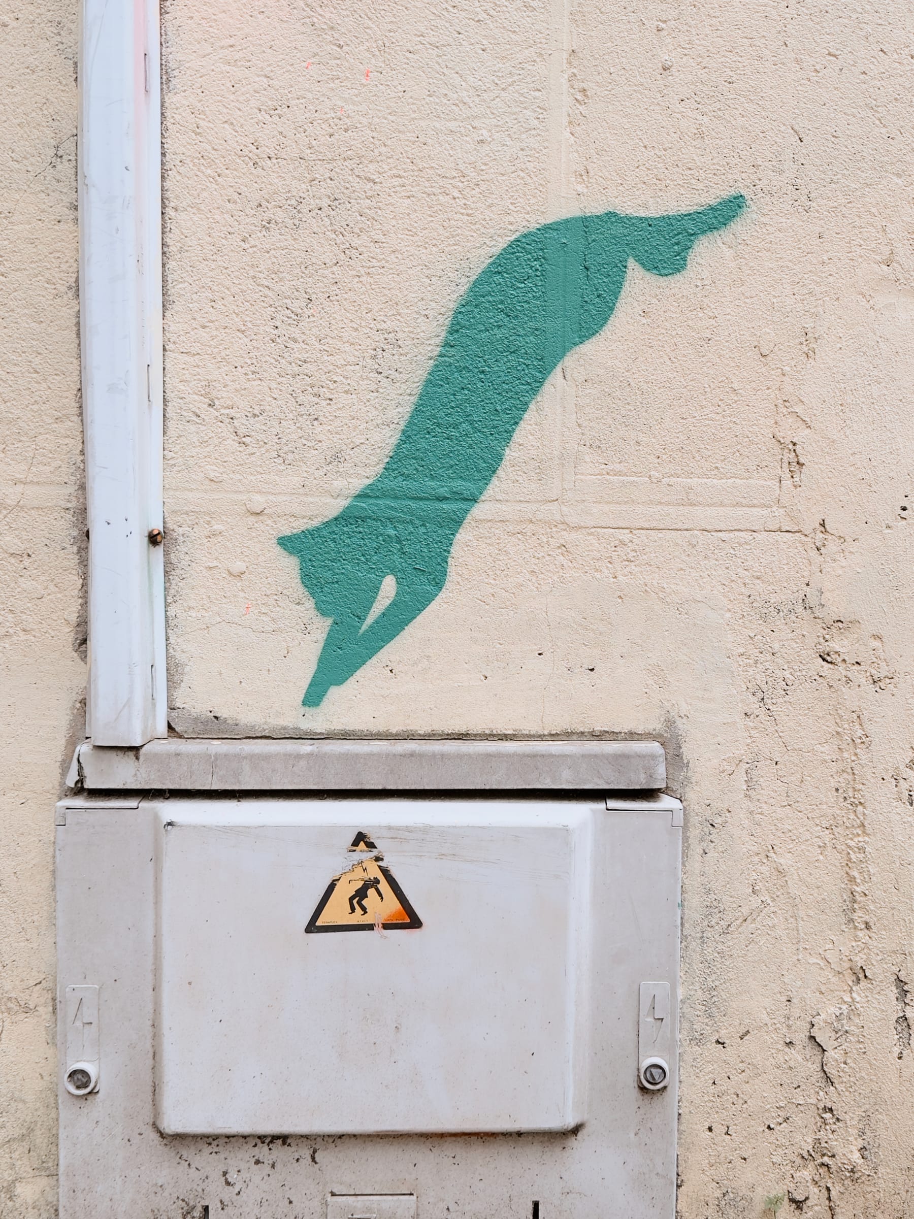 A mural of a green cat jumping in an electrical junction box.