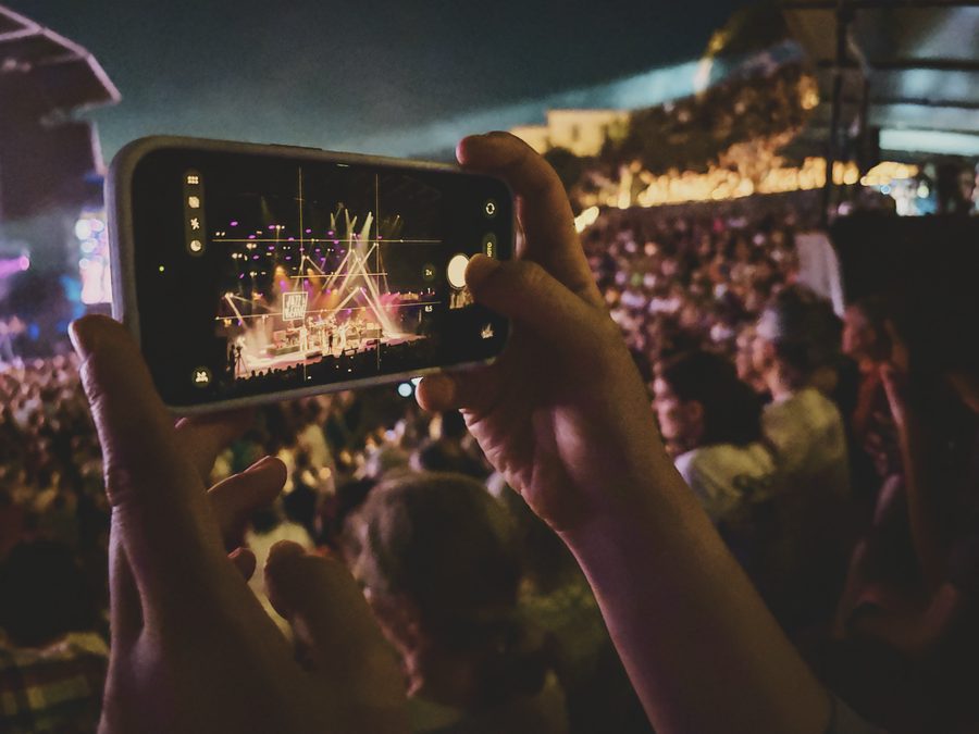 Someone taking a picture of a concert with a smartphone. Image Anthony Nelzin-Santos.