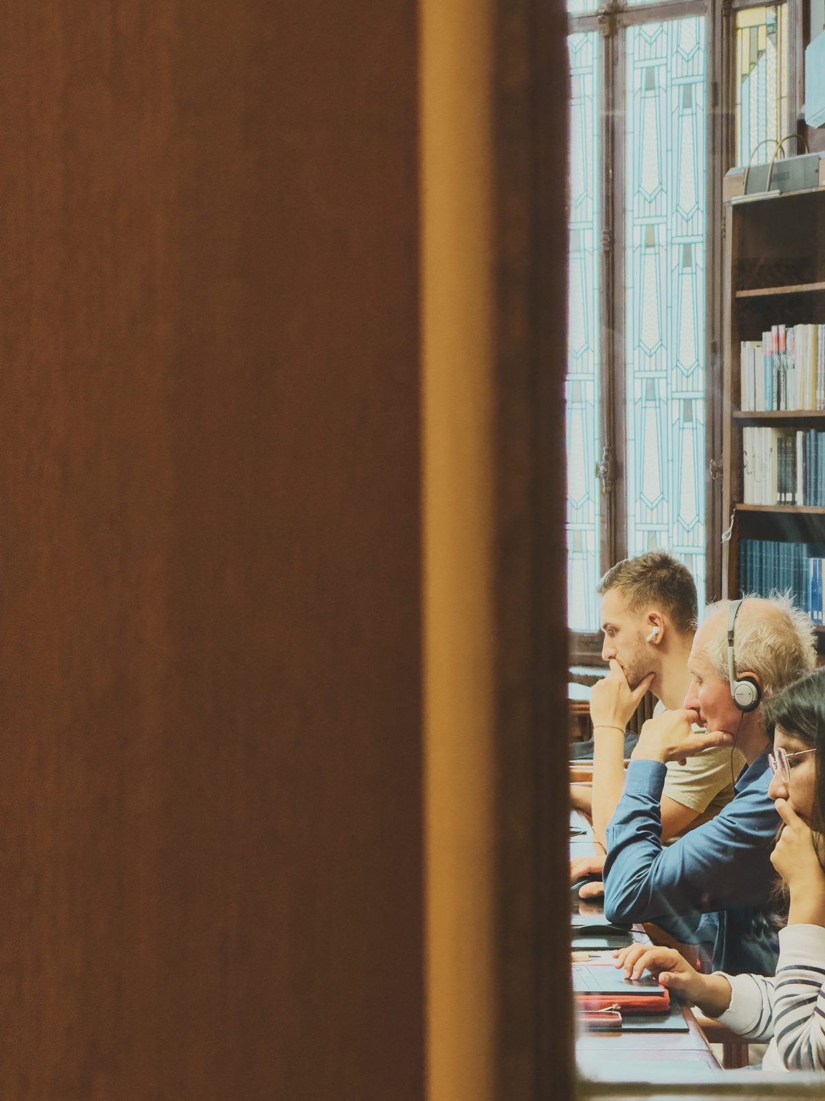 People working at the library, seen through a gap in a door. Image Anthony Nelzin-Santos.