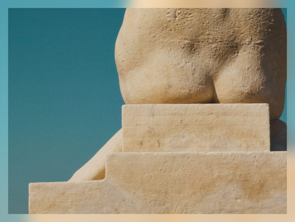 The bottom part of a statue of a woman.