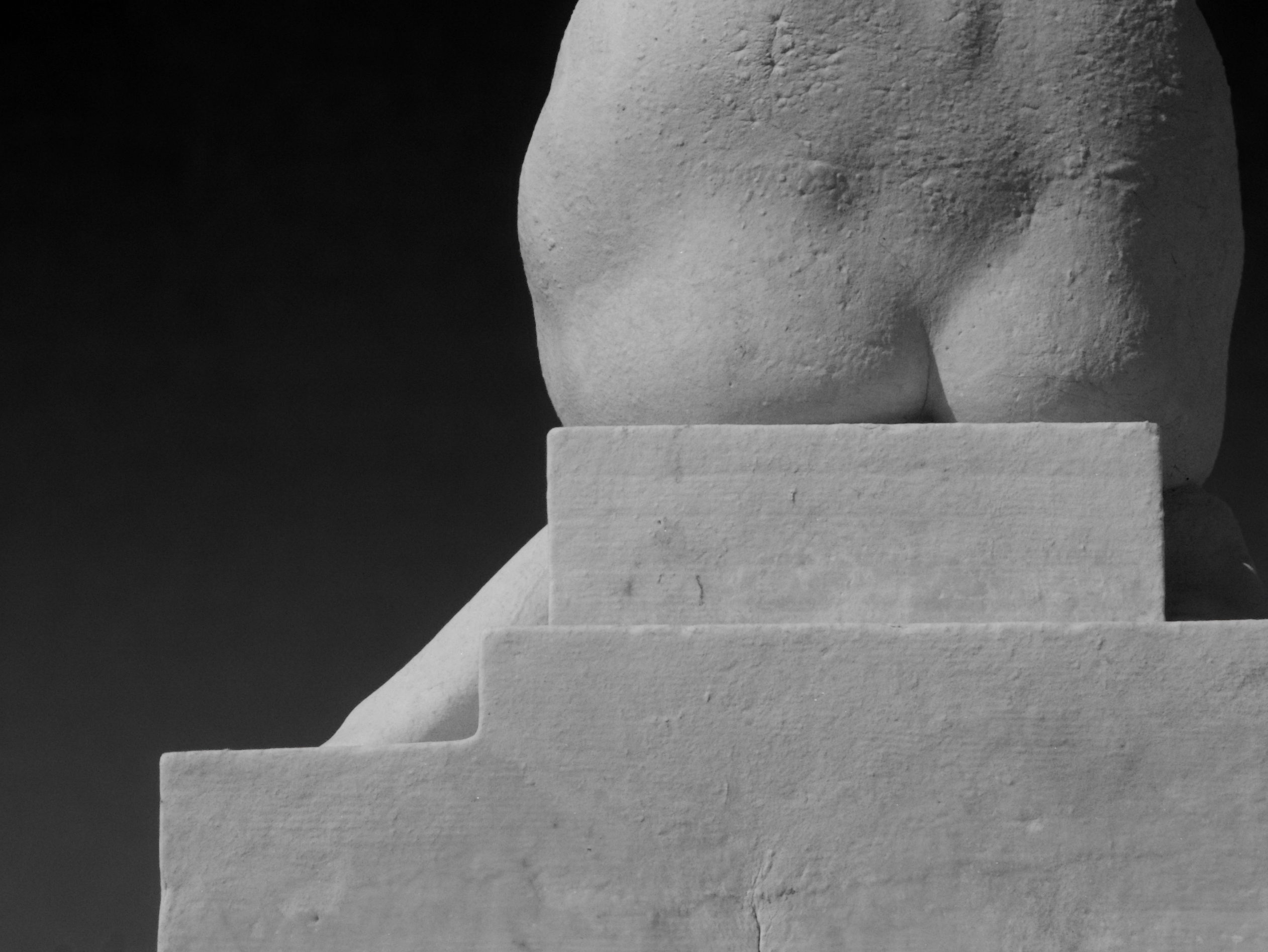The bottom part of a statue of a woman.