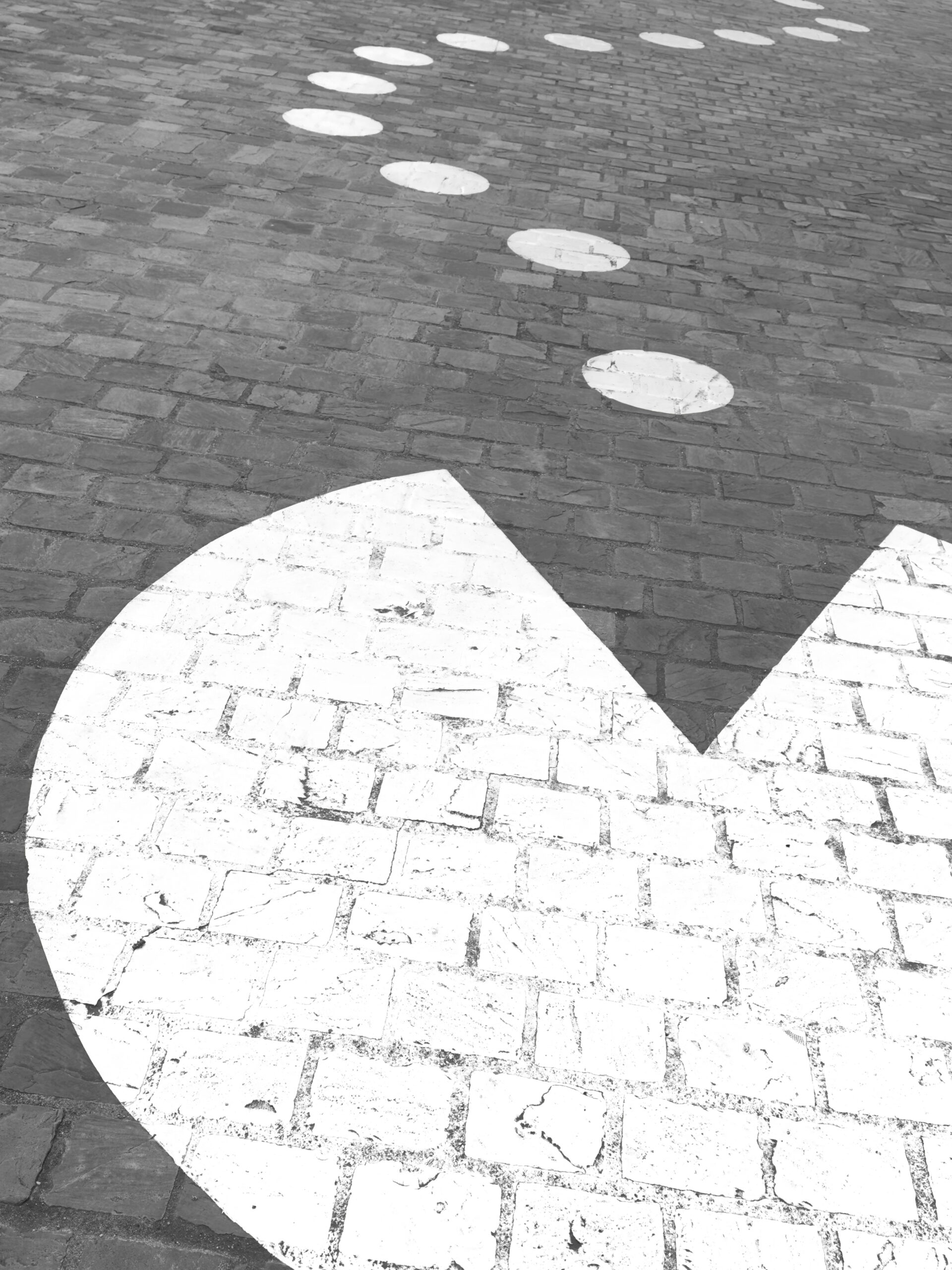A spray-painted Pacman on the pavement.