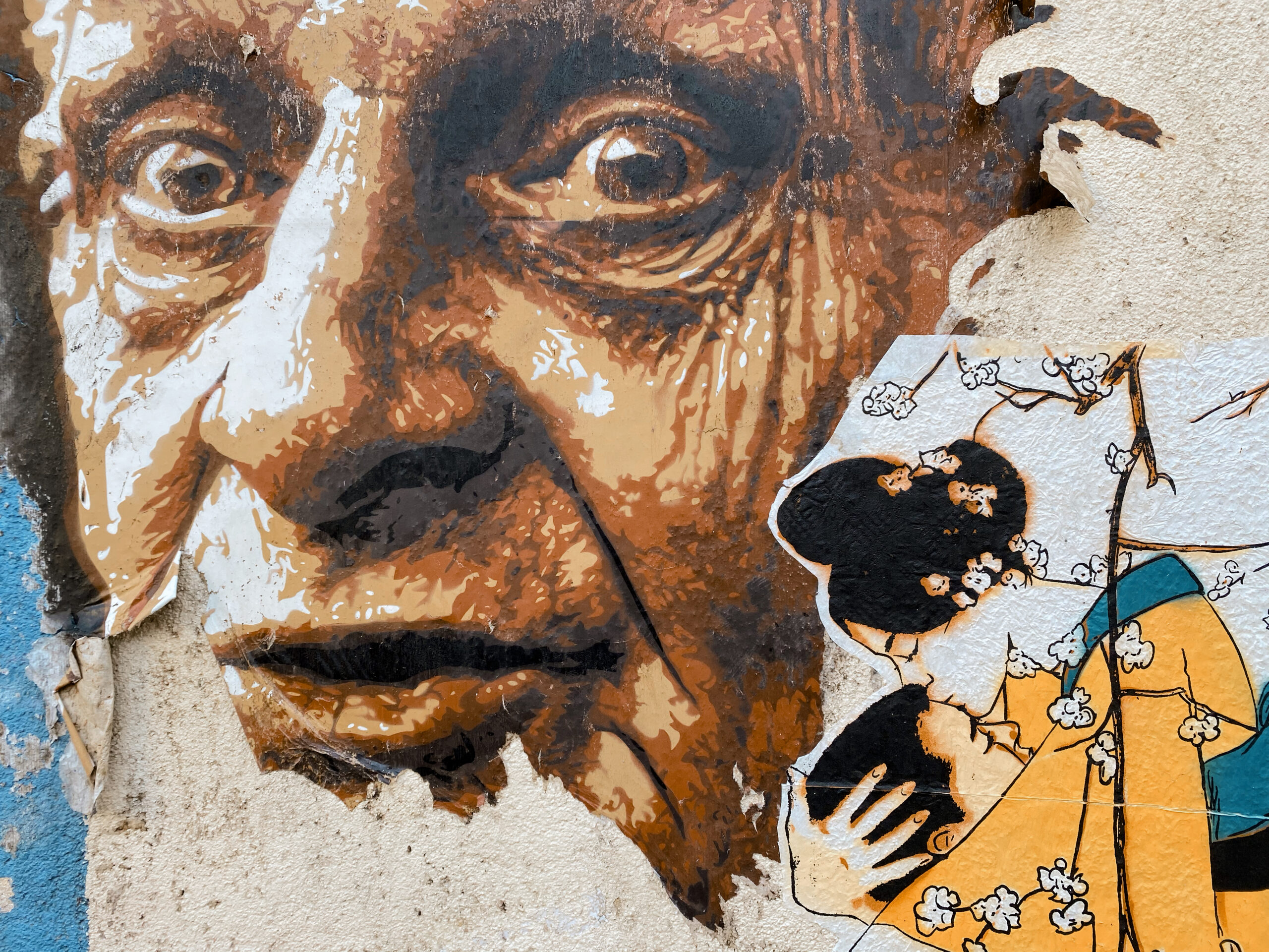 A torn mural of Picasso and ukiyo-e inspired characters.