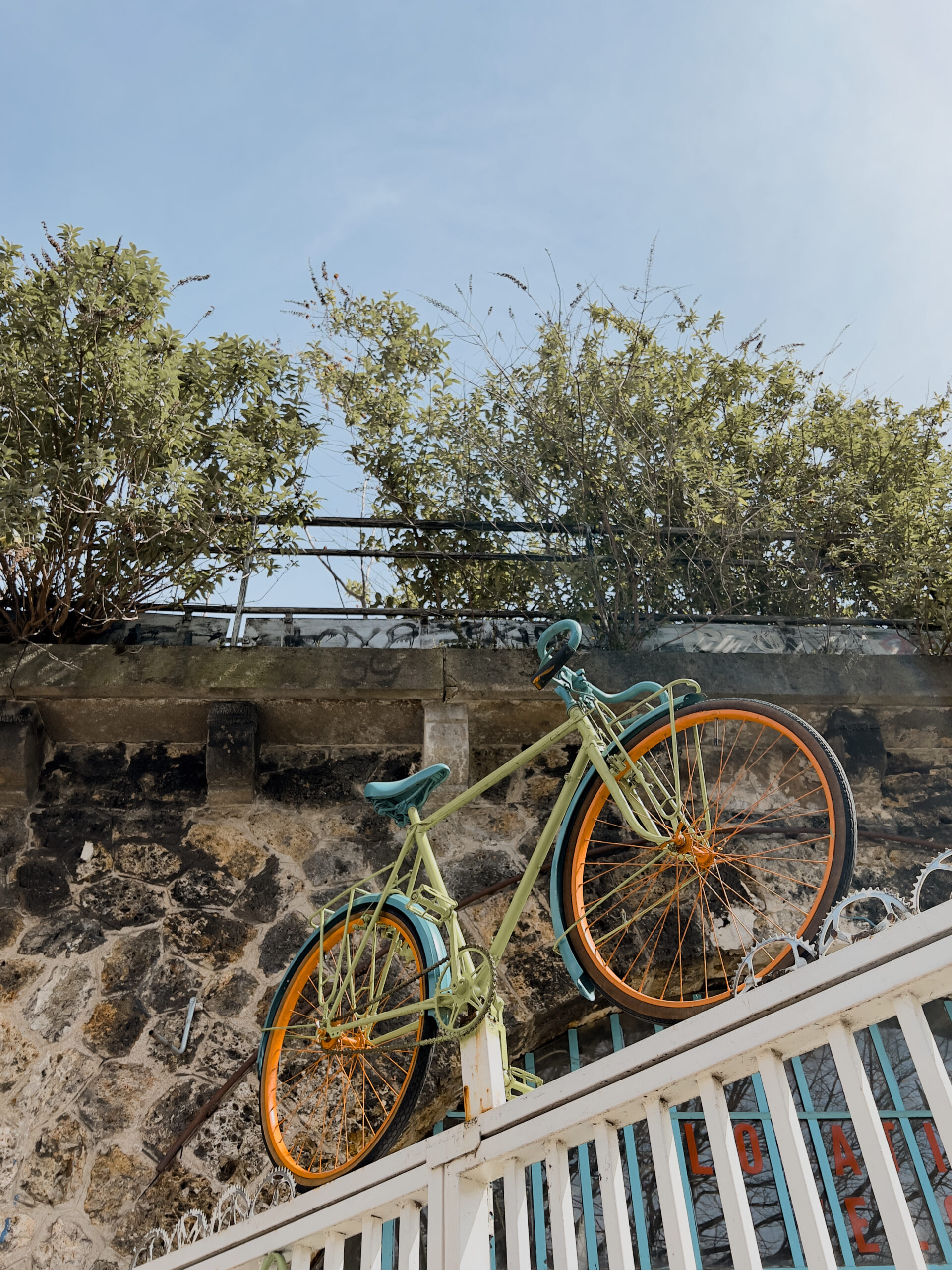 A colourful bike on top of the entrance grid of a bike shop.