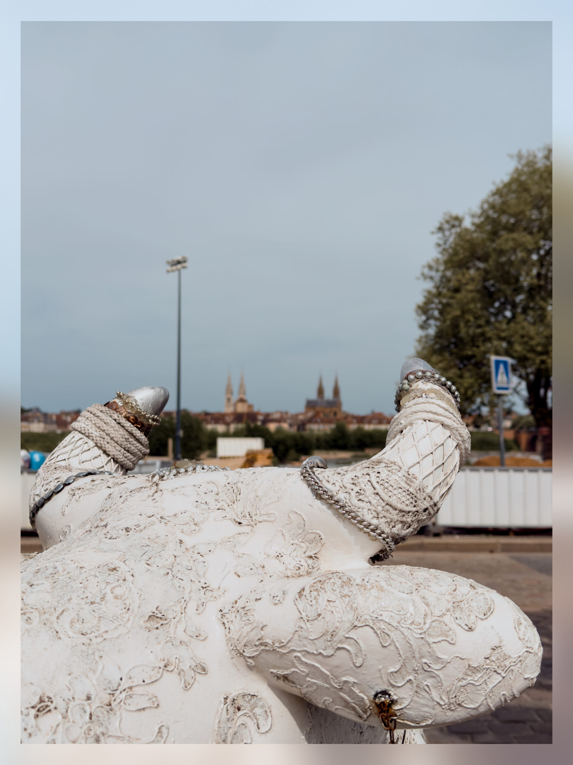 A sculpture of a cow overlooking the church and the cathedral of Moulins.